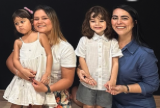 Mãe e filhas recebendo lembrancinha das professoras