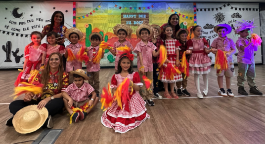 Turma completa em traje caipira xadrez vermelho e branco no palco