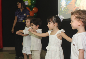 Crianças do Maternal dançando no palco com a professora