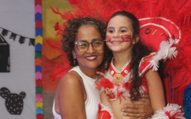 Mãe e filha com fantasia vermelha aproveitando a festa