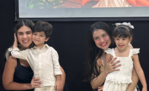Duas mães segurando seus filhos no colo durante a homenagem