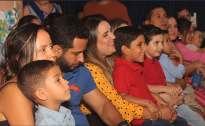 Famílias na plateia assistindo às apresentações do Dia das Mães